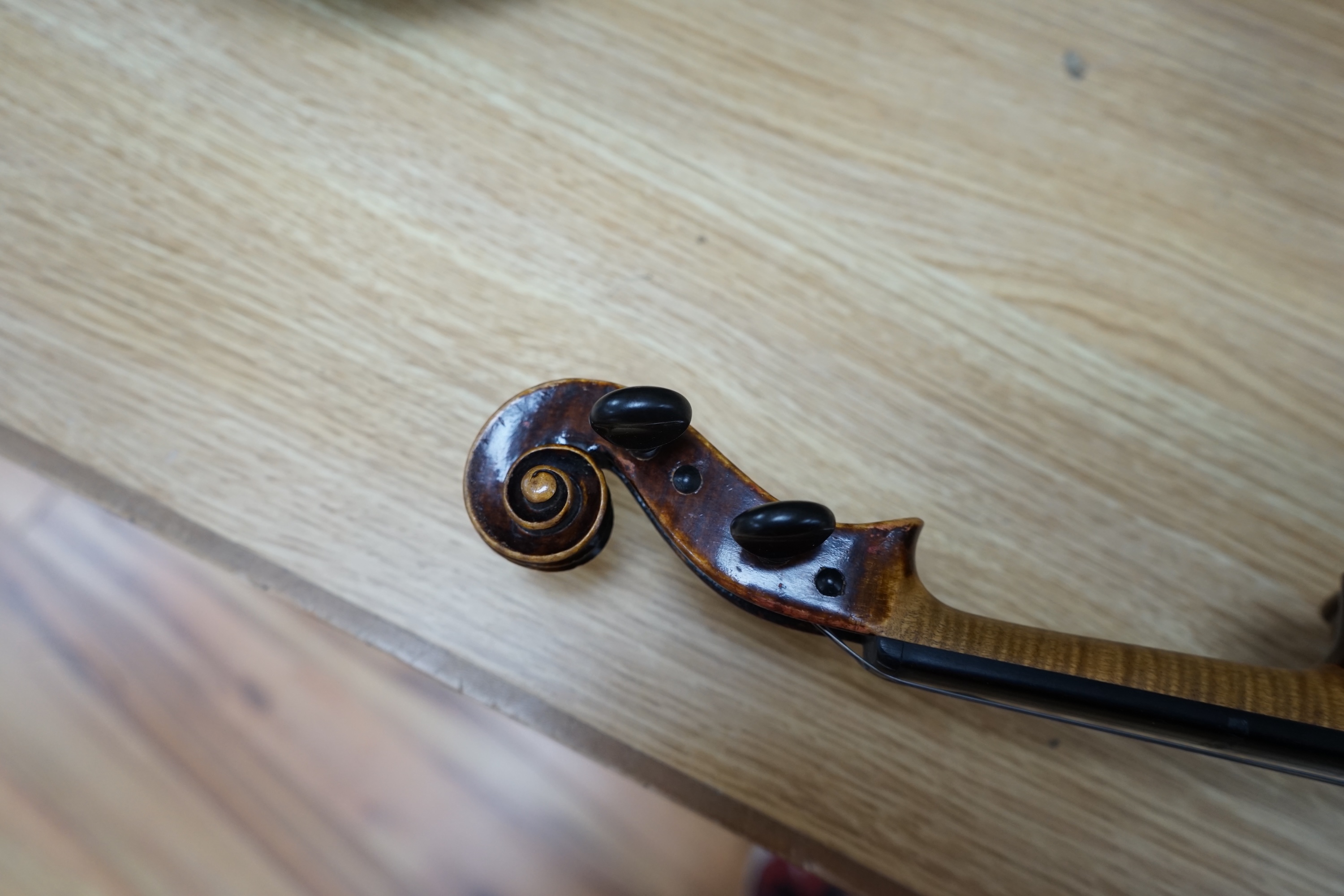 An early to mid 20th century violin, interior label reads ‘Copy of Antonius Straduarius made in Germany’, cased with bow, back measures 33.5cm. Condition - fair to good